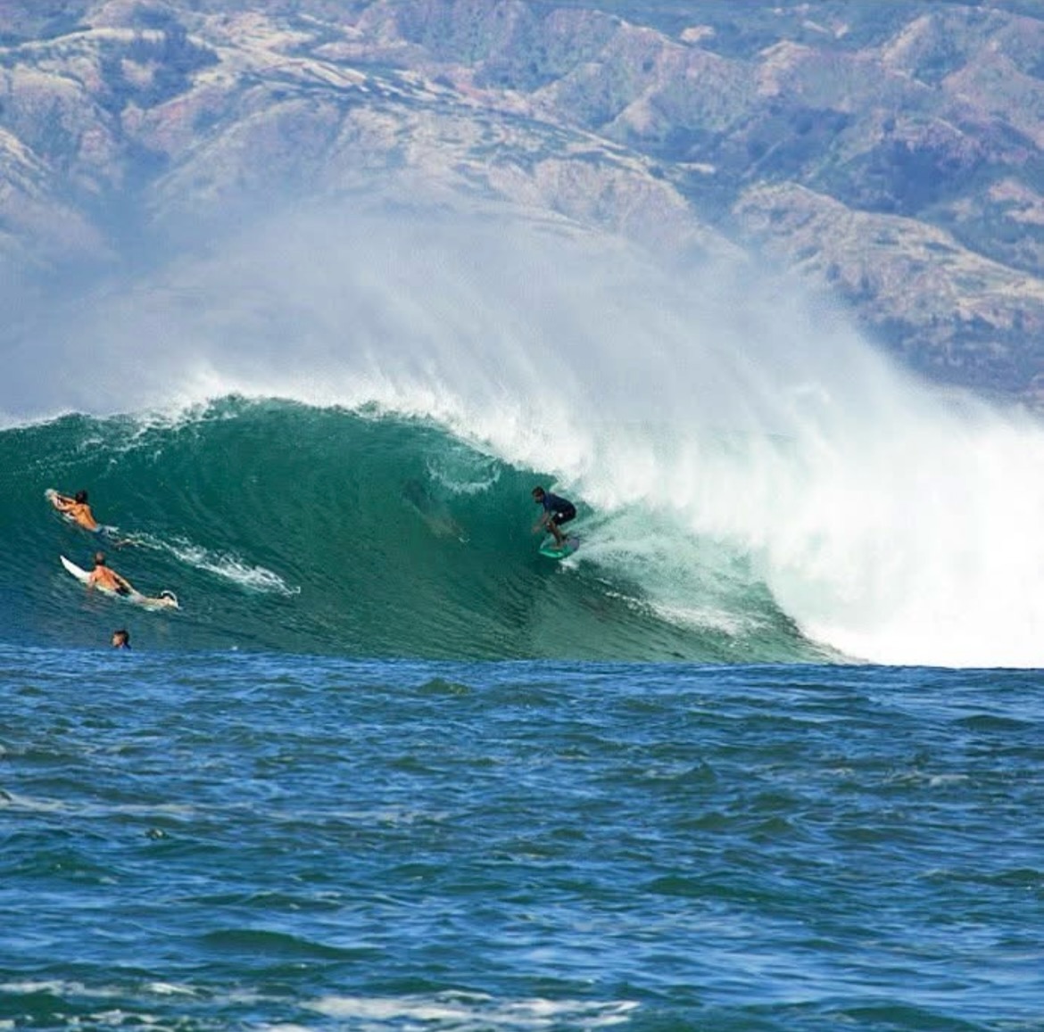 Surfer traveling across an ocean wave