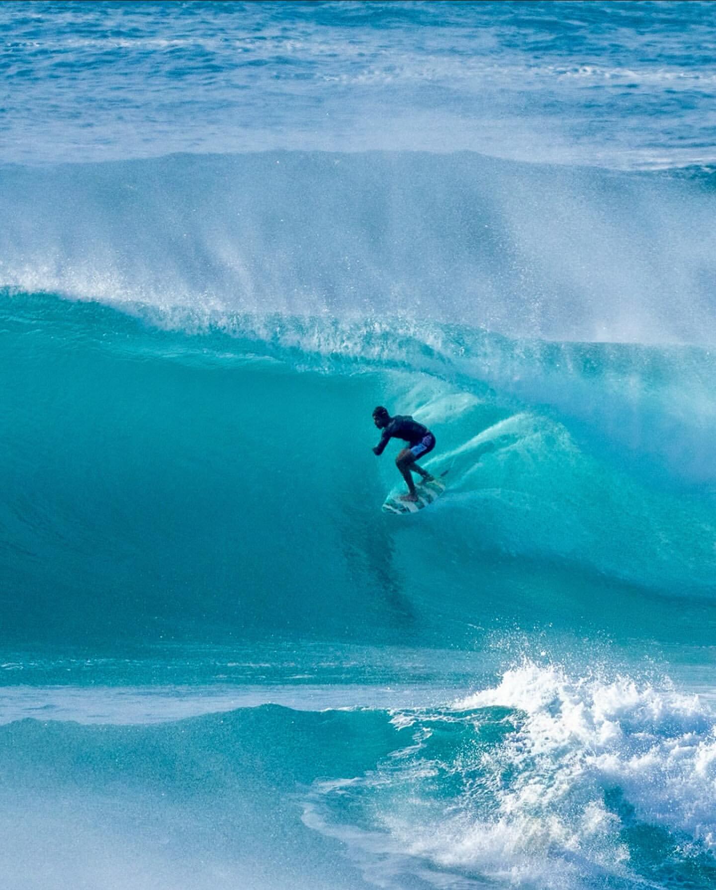 Surfer moving across a blue Maui wave